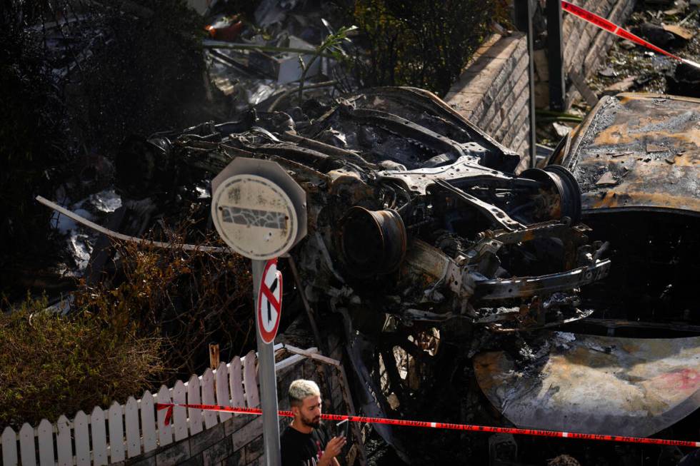 A man looks at the site hit by a rocket fired from Lebanon, in Kiryat Bialik, northern Israel, ...