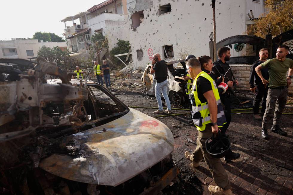 Israeli security forces examine the site hit by a rocket fired from Lebanon, in Kiryat Bialik, ...