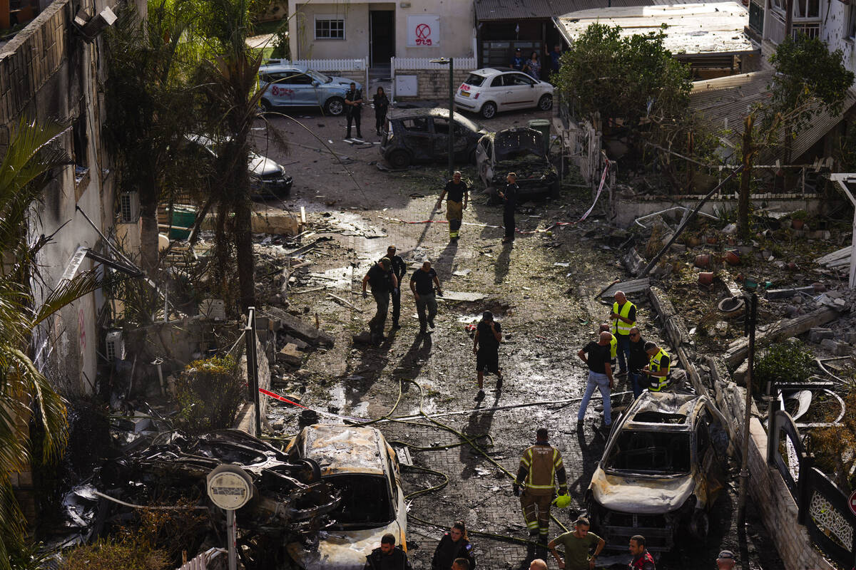 Israeli security forces examine the site hit by a rocket fired from Lebanon, in Kiryat Bialik, ...