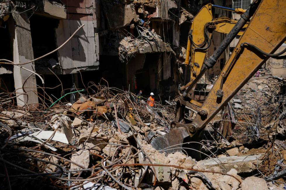 Rescuers sift through the rubble as they search for people still missing at the site of Friday' ...