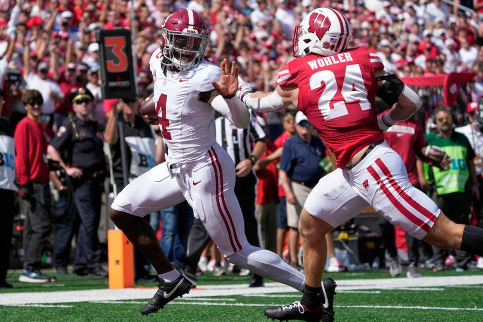 Alabama's Jalen Milroe (4) runs past Wisconsin's Hunter Wohler (24) for a touchdown during the ...