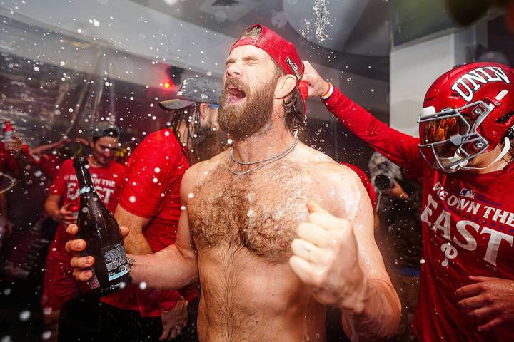 Phillies star Bryce Harper lets out a yell as fellow Las Vegan Bryson Stott pours champagne on ...