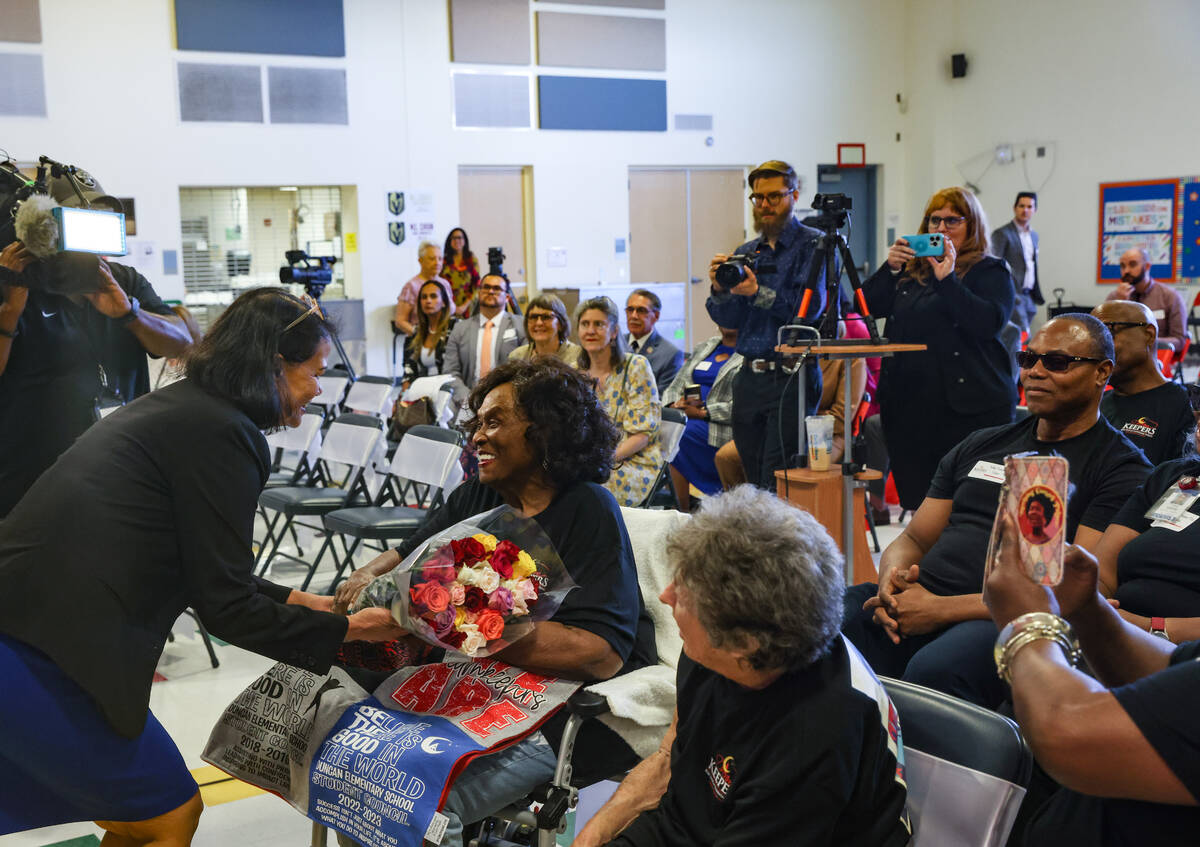 Superintendent of Public Instruction Jhone Ebert gifts flowers to Ruby Duncan, an activist ...