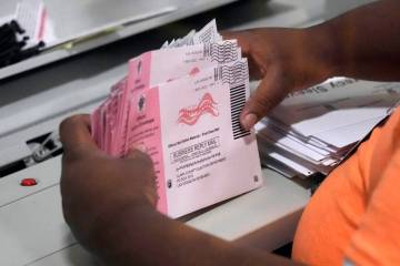 FILE - A worker handles mail-in ballots. (AP Photo/John Locher, File)