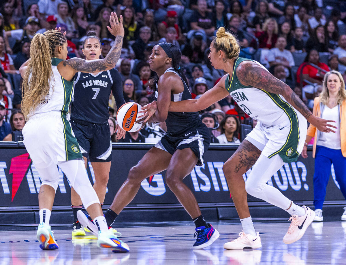 Aces guard Jackie Young (0) has the ball poked away by Seattle Storm center Mercedes Russell (2 ...