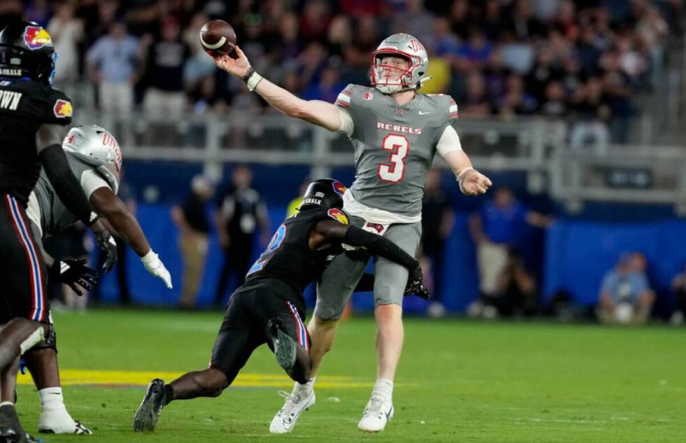 UNLV quarterback Matthew Sluka (3) passes as he is hit by Kansas cornerback Cobee Bryant (2) in ...