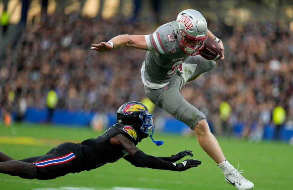 UNLV quarterback Matthew Sluka (3) leaps past Kansas cornerback Cobee Bryant (2) as he runs wit ...