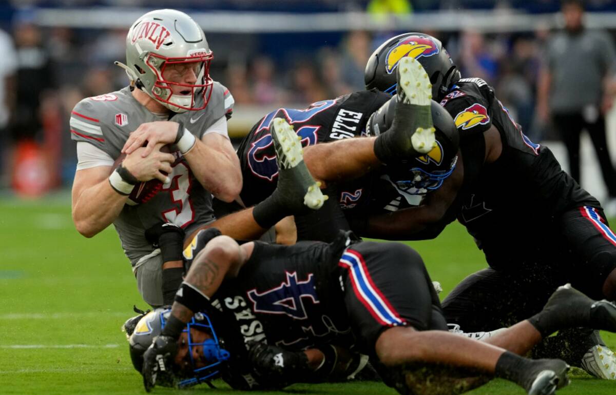 UNLV quarterback Matthew Sluka (3) is sacked by Kansas linebacker Cornell Wheeler (44) and safe ...