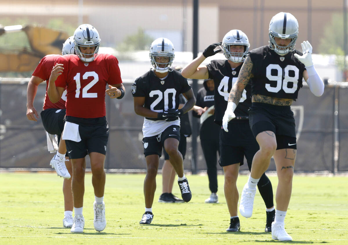 Raiders quarterback Aidan O'Connell (12), safety Isaiah Pola-Mao (20), linebacker Tommy Eichenb ...