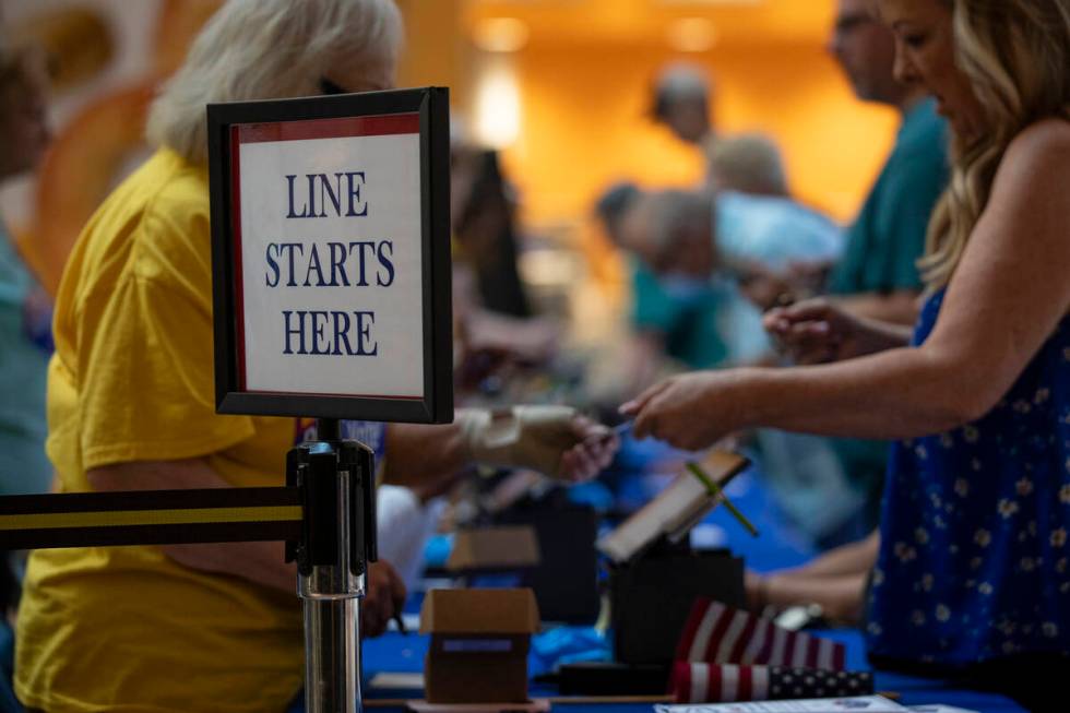 Voters fill out documents before casting their ballot during the Nevada Primary Day Elections o ...