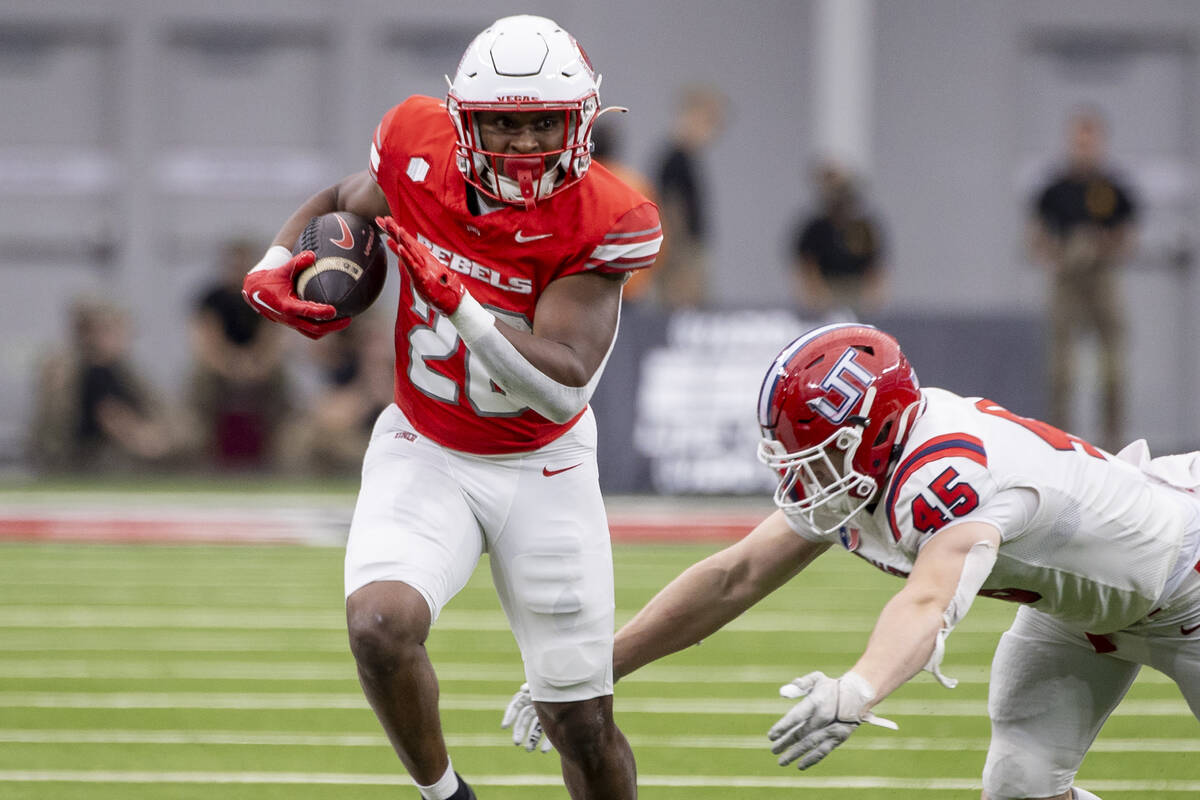 UNLV running back Michael Allen (26) outruns Utah Tech linebacker Spencer Rich (45) during the ...