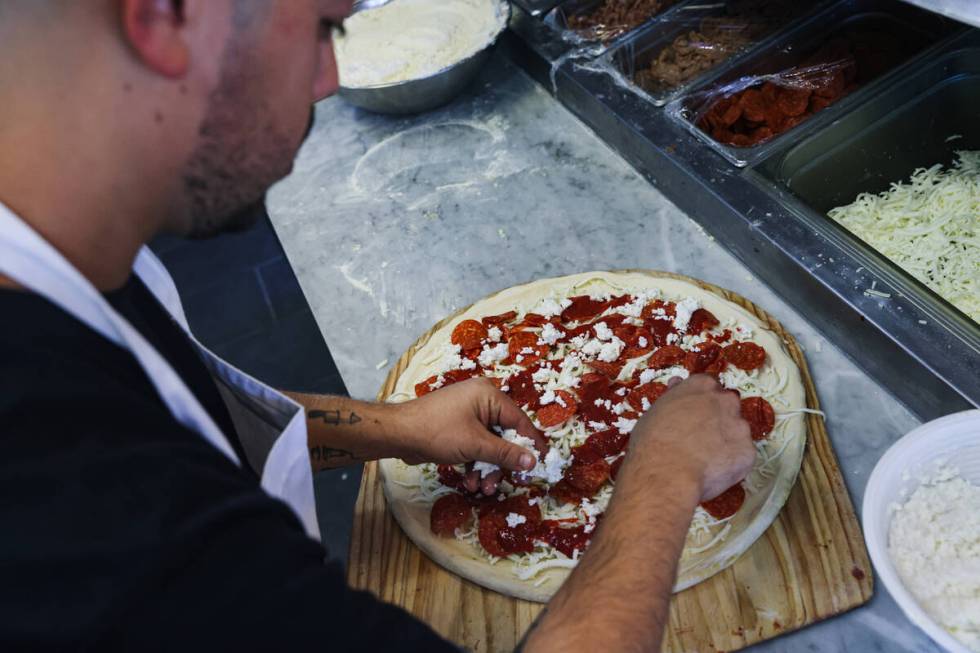 Owner Joey Scolaro prepares the Upside Down Pizza at Lucino’s pizza in Las Vegas, Thursd ...