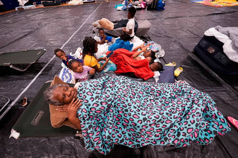 Vera Kelly, of Tallahassee, lies on a cot after evacuating to a hurricane shelter with her gran ...