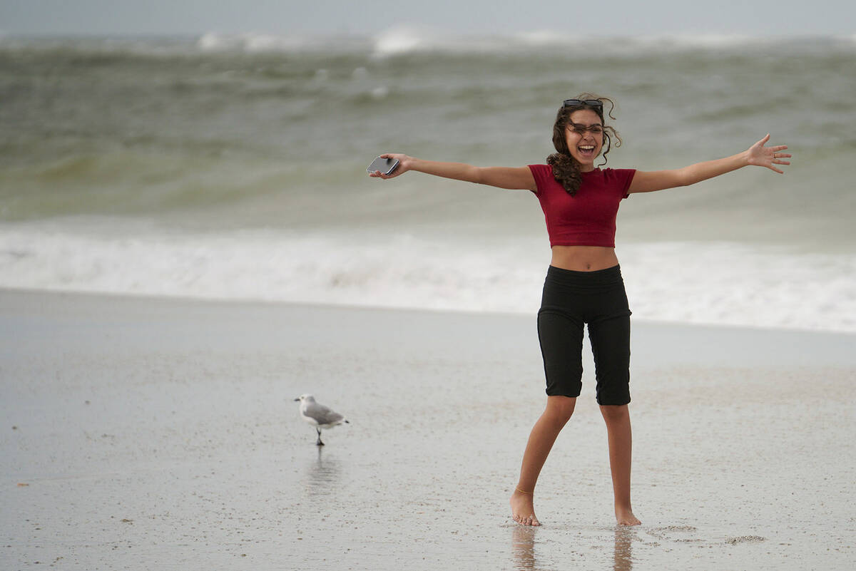 Lina Anasri, 19, enjoys the winds and waves along the beach as Hurricane Helene makes its way t ...