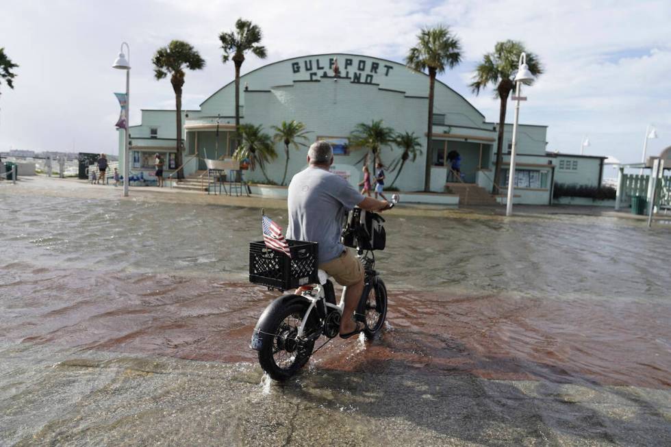 Louis Ward, 57, rides his bike along the the Gulfport waterfront as it takes on water as Hurric ...