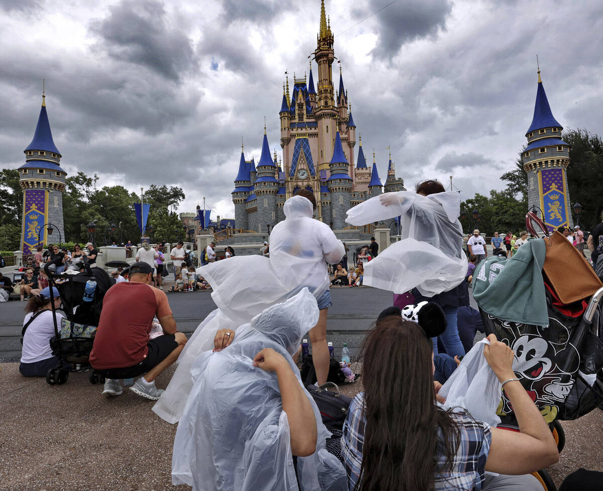 Guests at the Magic Kingdom break out ponchos at Cinderella Castle as bands of weather from Hur ...