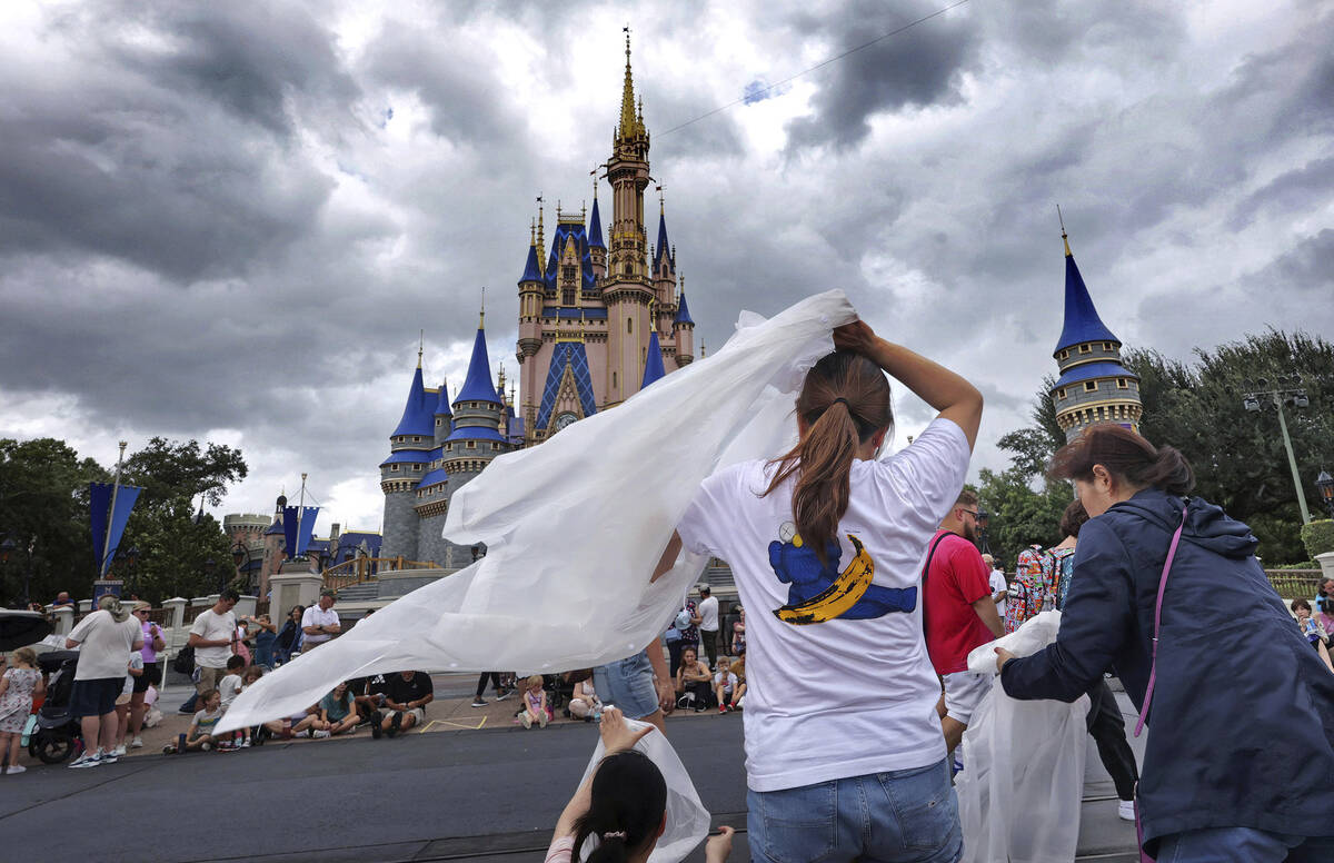 Guests at the Magic Kingdom break out ponchos at Cinderella Castle as bands of weather from Hur ...