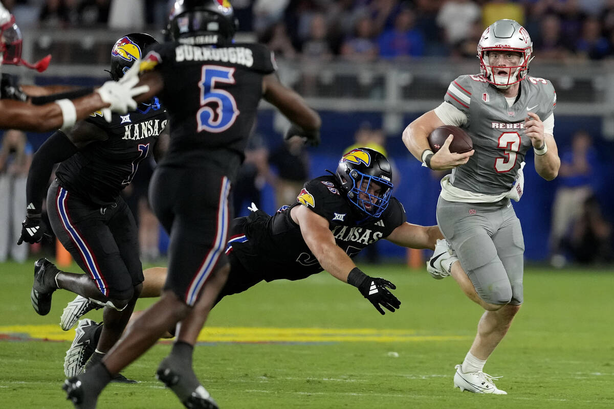 UNLV quarterback Matthew Sluka (3) gets past Kansas defensive end Dylan Wudke (95) as he runs i ...