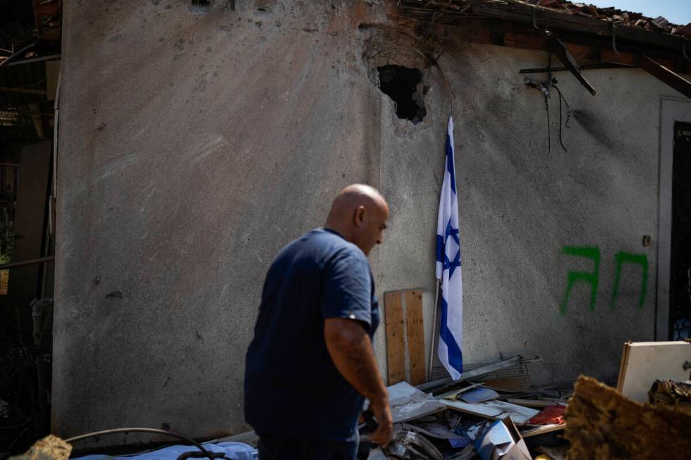 A man looks at a damaged house that was hit by a rocket fired from Lebanon, near Safed, norther ...