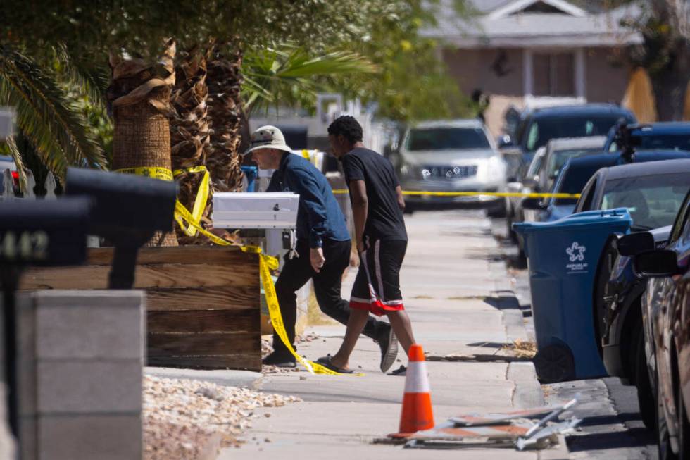 An unidentified individual, right, is seen as Las Vegas police investigate a homicide on the 64 ...