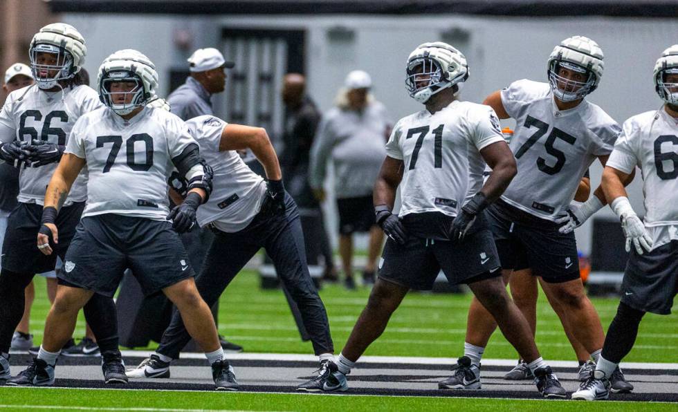 Raiders guard Jackson Powers-Johnson (70) and offensive tackle DJ Glaze (71) join teammates in ...