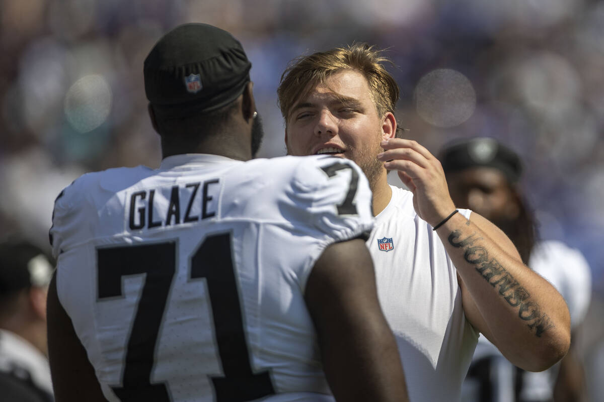 Raiders guard Jackson Powers-Johnson speaks to Raiders offensive tackle DJ Glaze (71) on the si ...