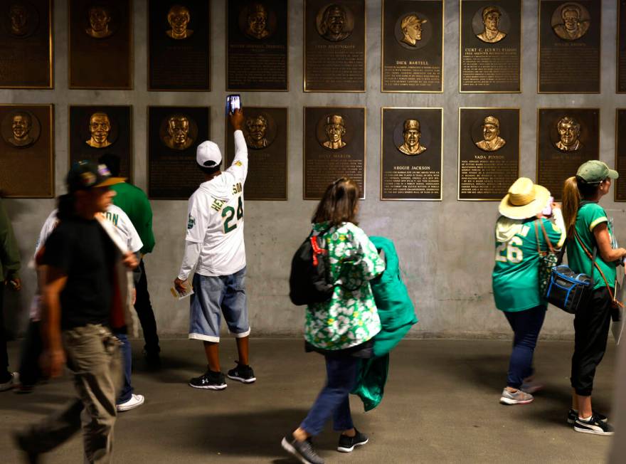 Fans take pictures of former Oakland Athletics players plaques along the second level concourse ...