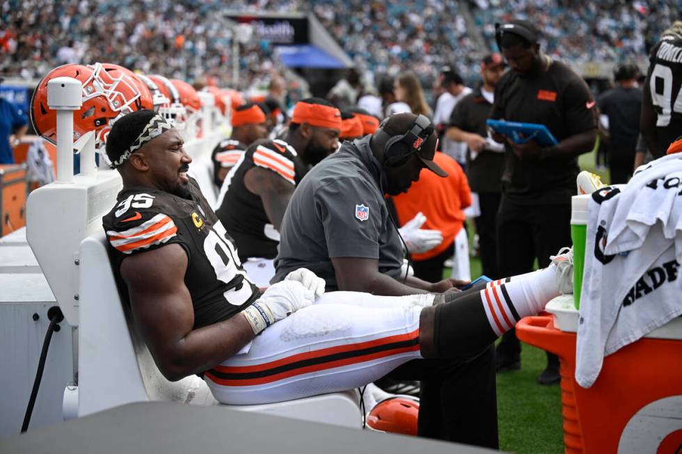 Cleveland Browns defensive end Myles Garrett (95) rests his feet while sitting on the bench dur ...