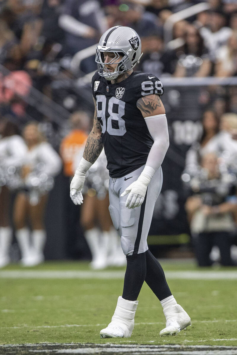 Raiders defensive end Maxx Crosby (98) wears a walking boot on his left ankle on the field duri ...