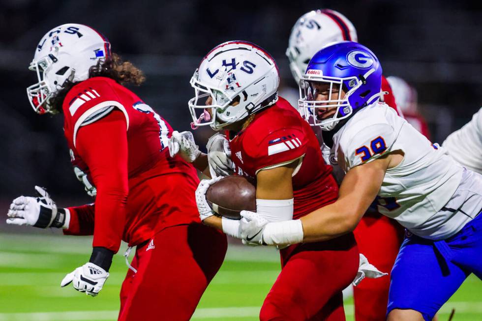 Liberty running back Ezra Sanelivi (1) scurries with the ball as Bishop Gorman defensive linema ...