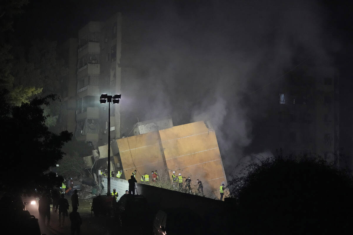 Rescuers arrive at the site of an Israeli airstrike in Beirut's southern suburbs, Friday, Sept. ...