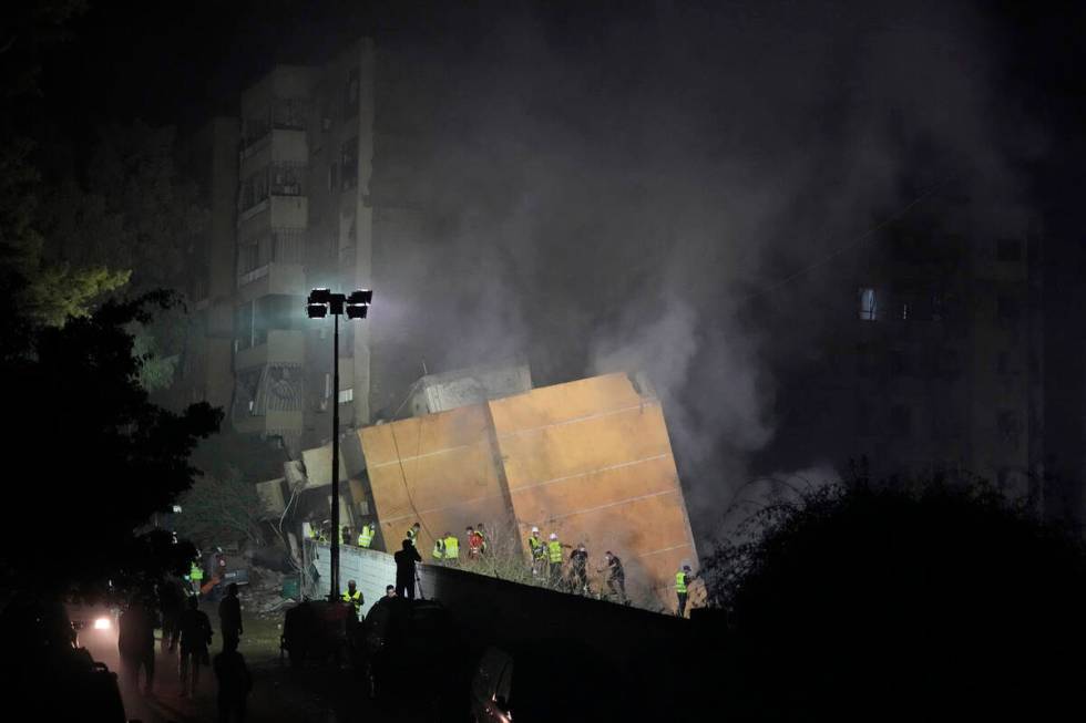 Rescuers arrive at the site of an Israeli airstrike in Beirut's southern suburbs, Friday, Sept. ...