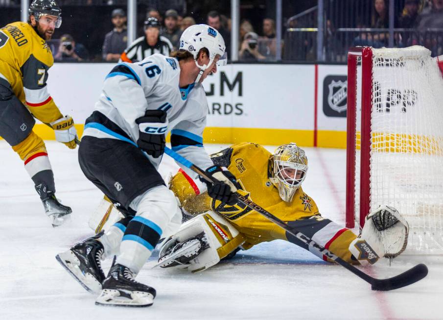 Golden Knights goaltender Adin Hill (33) looks to stop a shot by Utah Hockey Club forward Ryan ...