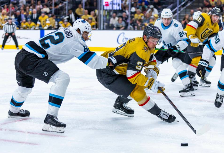 Golden Knights center Jack Eichel (9) looks to control the puck with Utah Hockey Club forward K ...