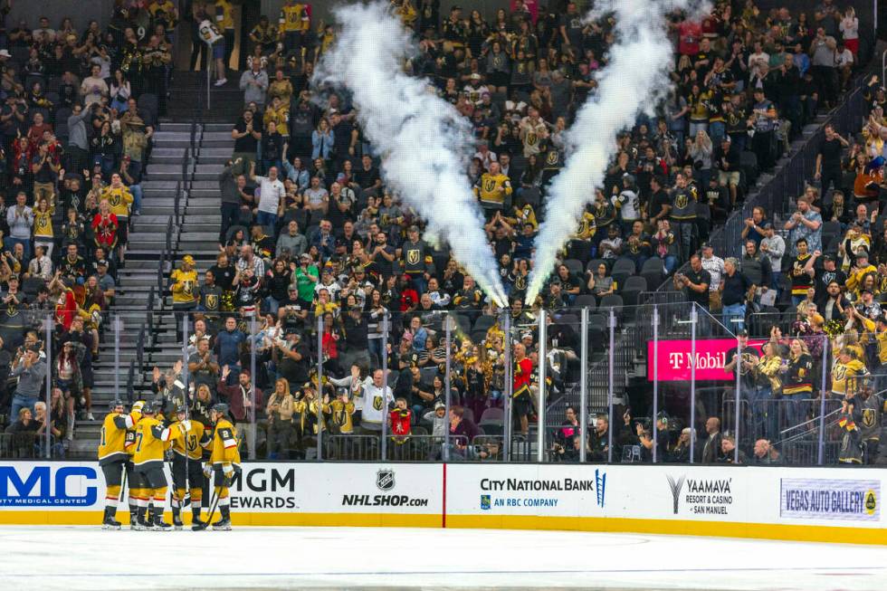 Golden Knights players celebrate a goal against Utah Hockey Club goaltender Jaxson Stauber (33) ...