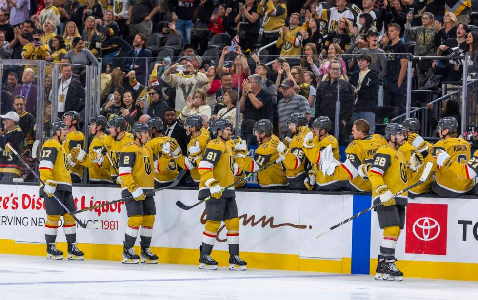 Golden Knights players celebrate a goal against Utah Hockey Club goaltender Jaxson Stauber (33) ...