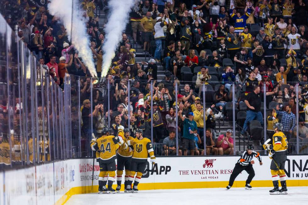 Golden Knights players celebrate a goal against Utah Hockey Club goaltender Jaxson Stauber (33) ...