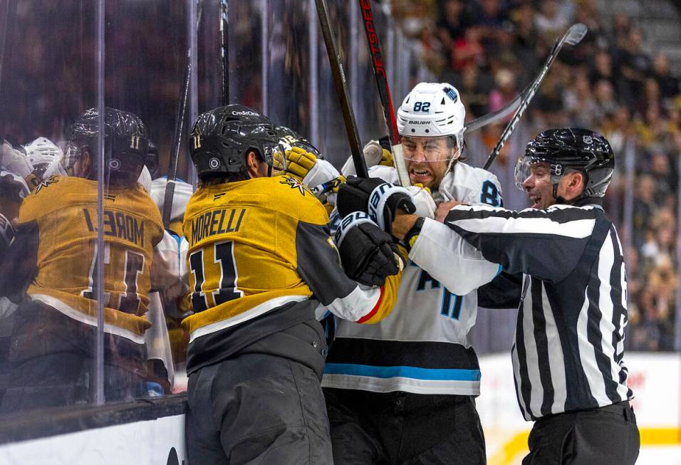 Golden Knights left wing Mason Morelli (11) fights with Utah Hockey Club forward Kevin Stenlund ...