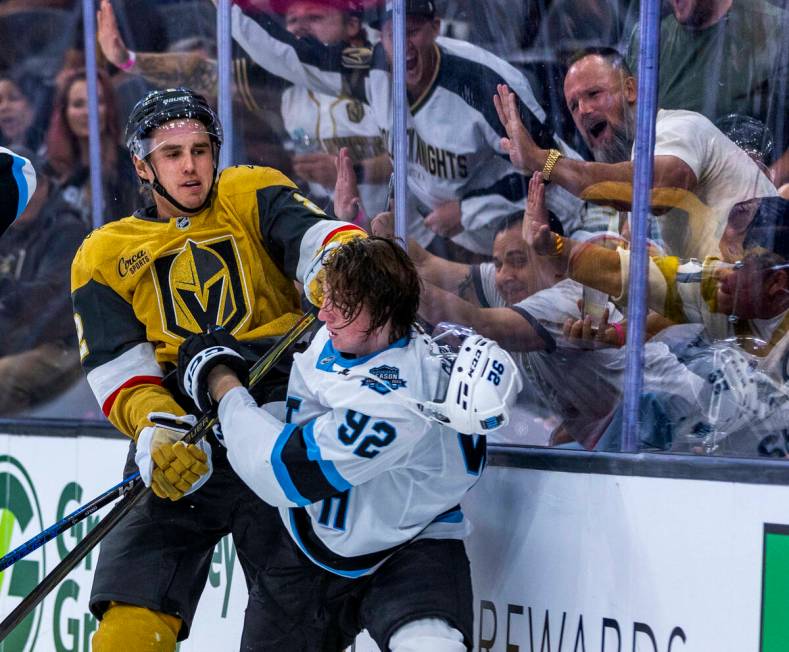 Golden Knights defenseman Zach Whitecloud (2) punches Utah Hockey Club forward Logan Cooley (92 ...