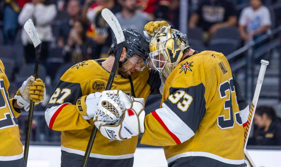 Golden Knights defenseman Shea Theodore (27) congratulates goaltender Adin Hill (33) on their w ...