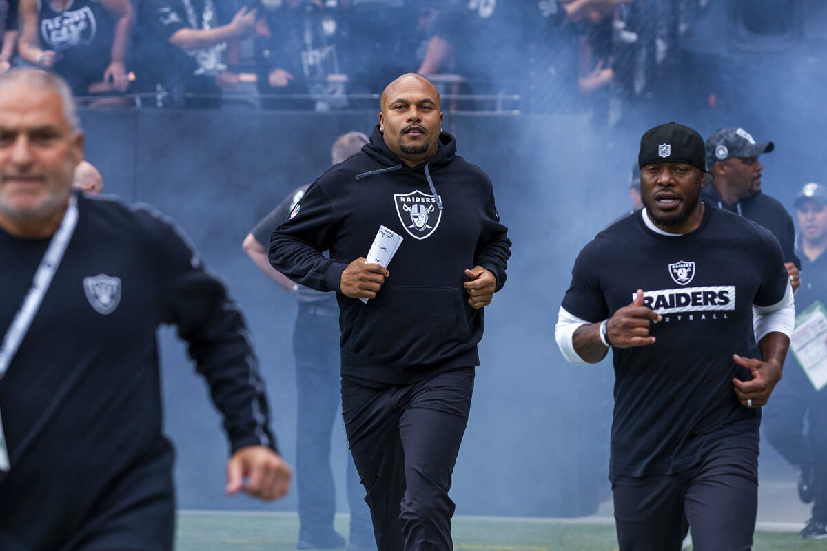 Raiders Head Coach Antonio Pierce and others take the field before the first half of the Raider ...