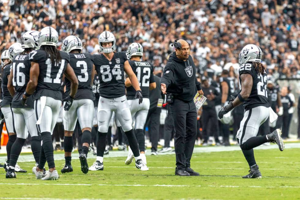 Raiders head coach Antonio Pierce greets Raiders running back Alexander Mattison (22) after his ...