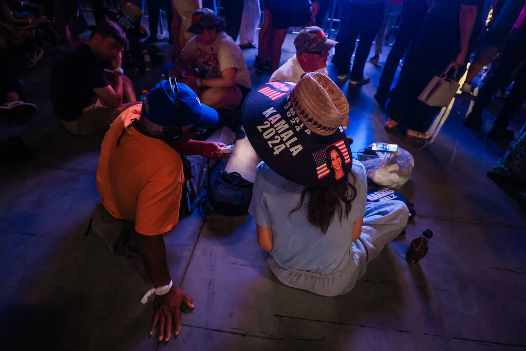 Supporters sit on the ground while waiting for a campaign event for Democratic presidential nom ...