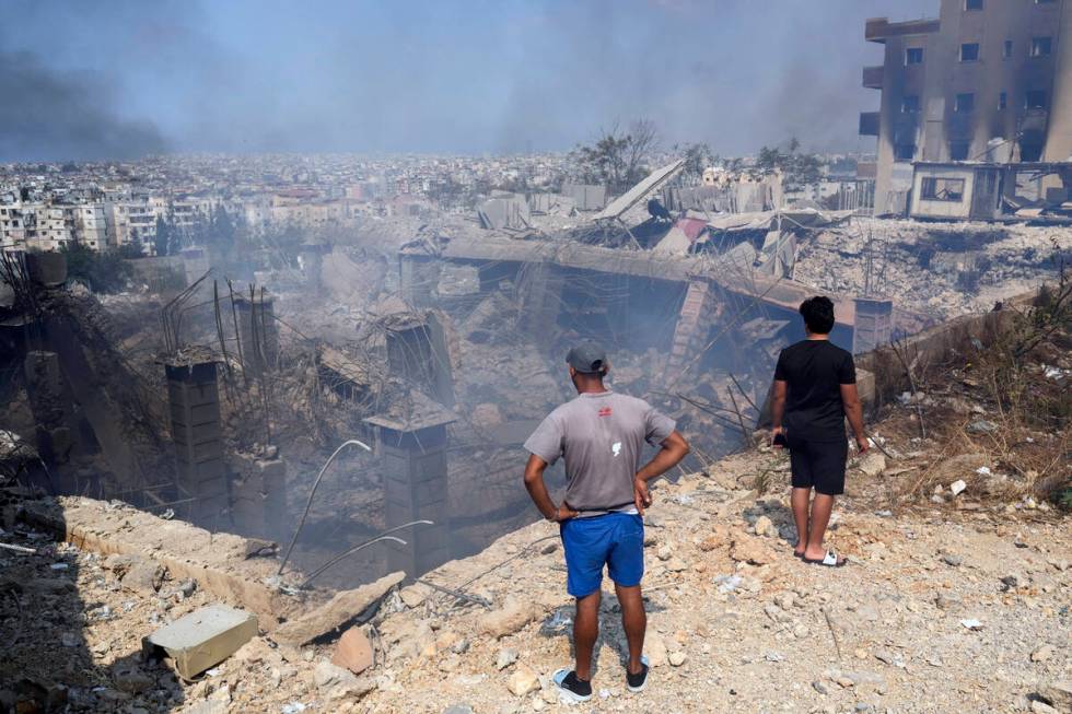 People check a damaged building at the site of an Israeli airstrike in Choueifat, south east of ...