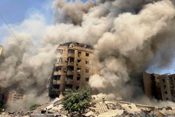 Smoke rises as a building collapses in Beirut's southern suburbs, Saturday, Sept. 28, 2024. (AP ...