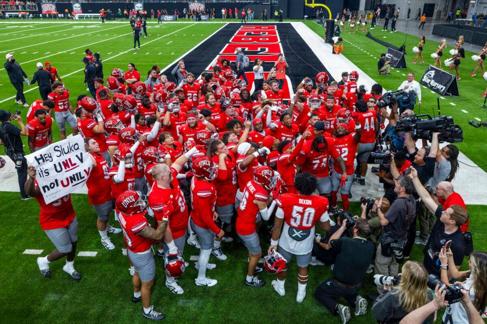 UNLV players celebrate their big win over the Fresno State Bulldogs with their fans in the end ...