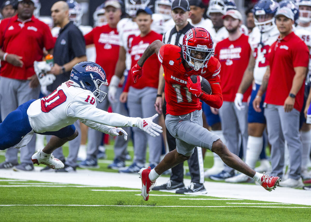 UNLV wide receiver Ricky White III (11) gets past Fresno State defensive back Kosi Agina (10) f ...