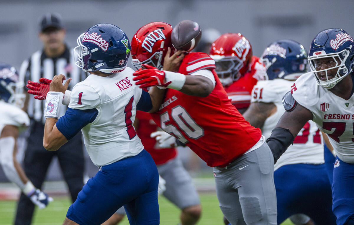 Fresno State quarterback Mikey Keene (1) has the ball stripped on a pass by UNLV defensive line ...