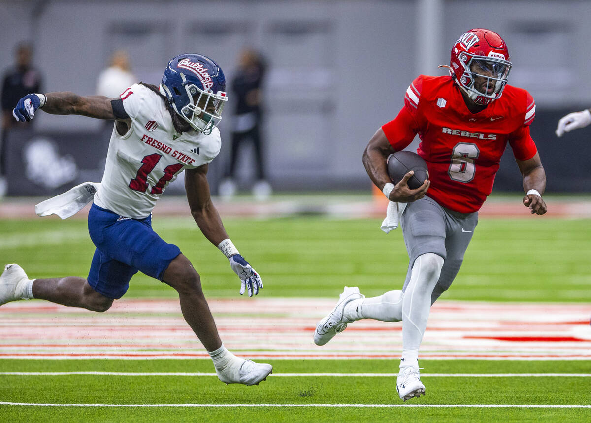 UNLV quarterback Hajj-Malik Williams (6) sprints into open field pursued by Fresno State Bulldo ...