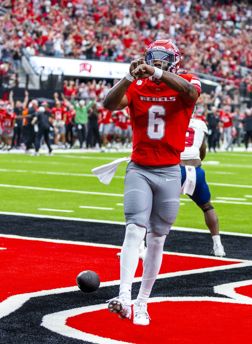 UNLV quarterback Hajj-Malik Williams (6) taps an imaginary watch on his wrist after scoring his ...